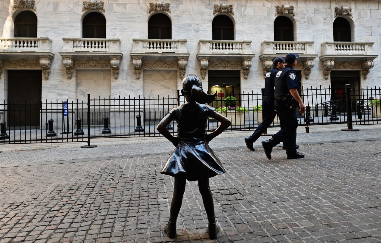 Two New York Police Officers walk past the 'Fearless Girl' statue at The New York Stock Exchange (NYSE)  at Wall Street on June 29, 2020 in New York City. Stock markets on both sides of the Atlantic struggled Monday to rebound from last week's losses as optimism over easing lockdowns was torpedoed by fear over surging coronavirus infections.
Angela Weiss / AFP