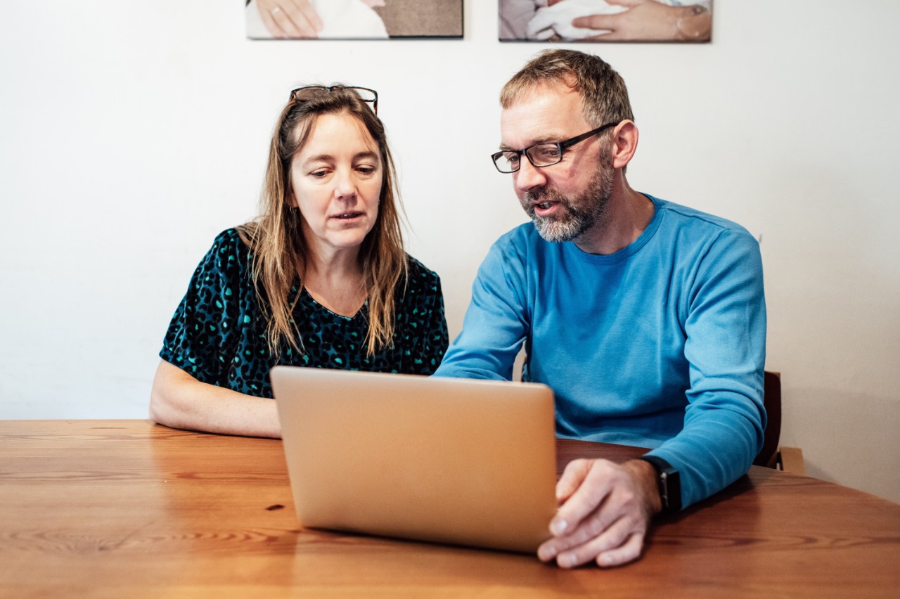 Man en vrouw thuis achter een laptop.