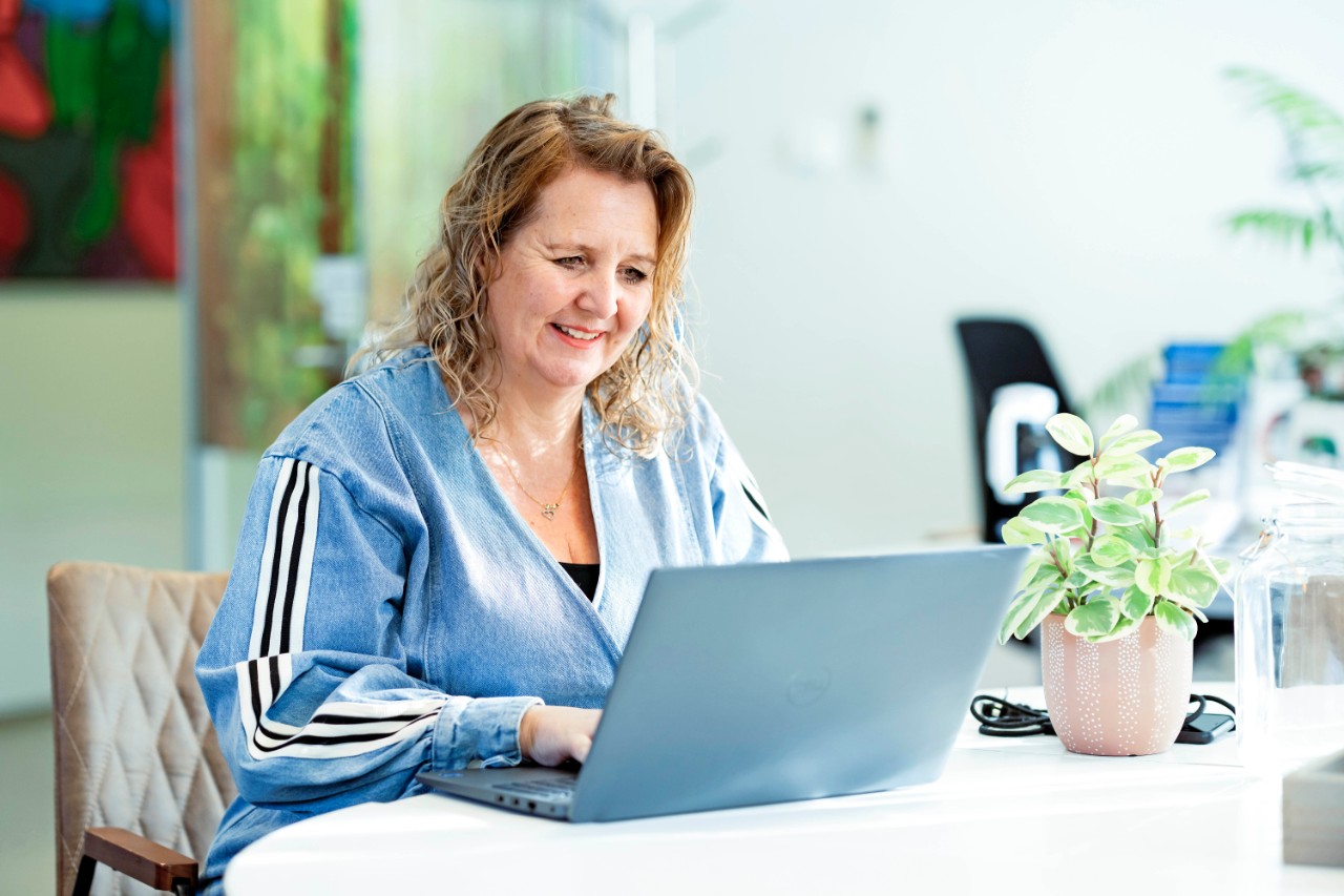 Vrouw doet administratie achter laptop