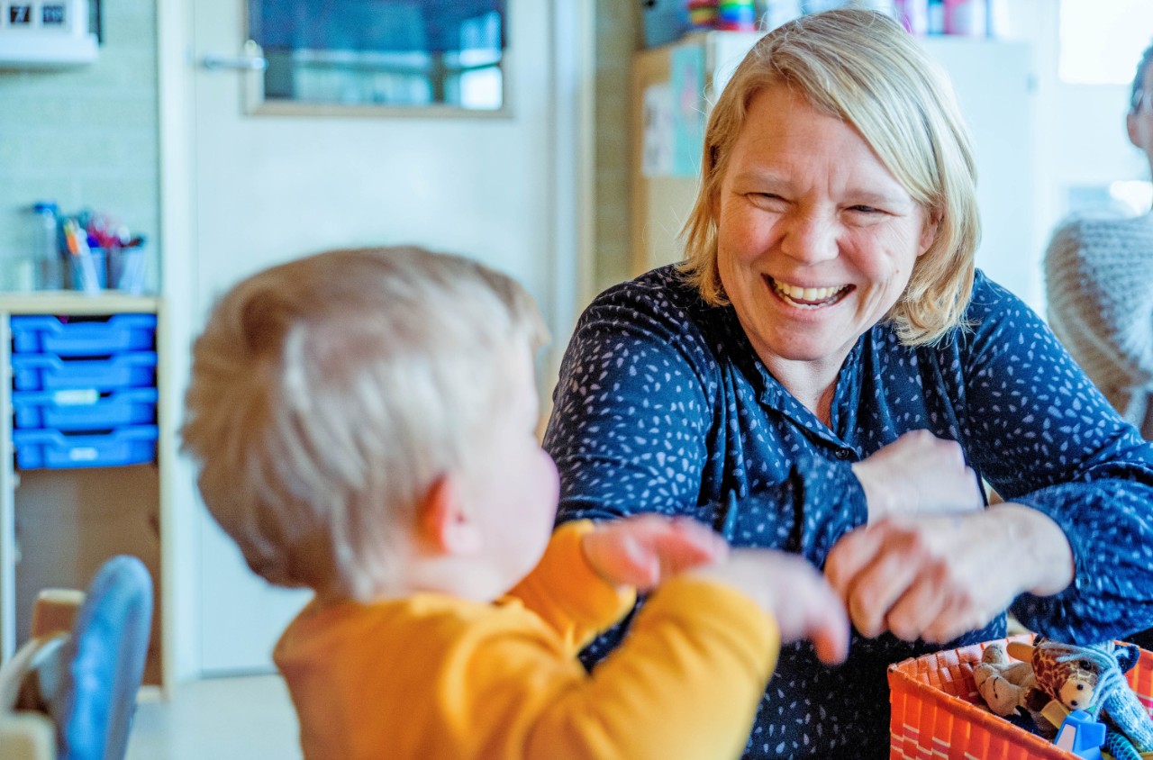 lachende juf met kind school