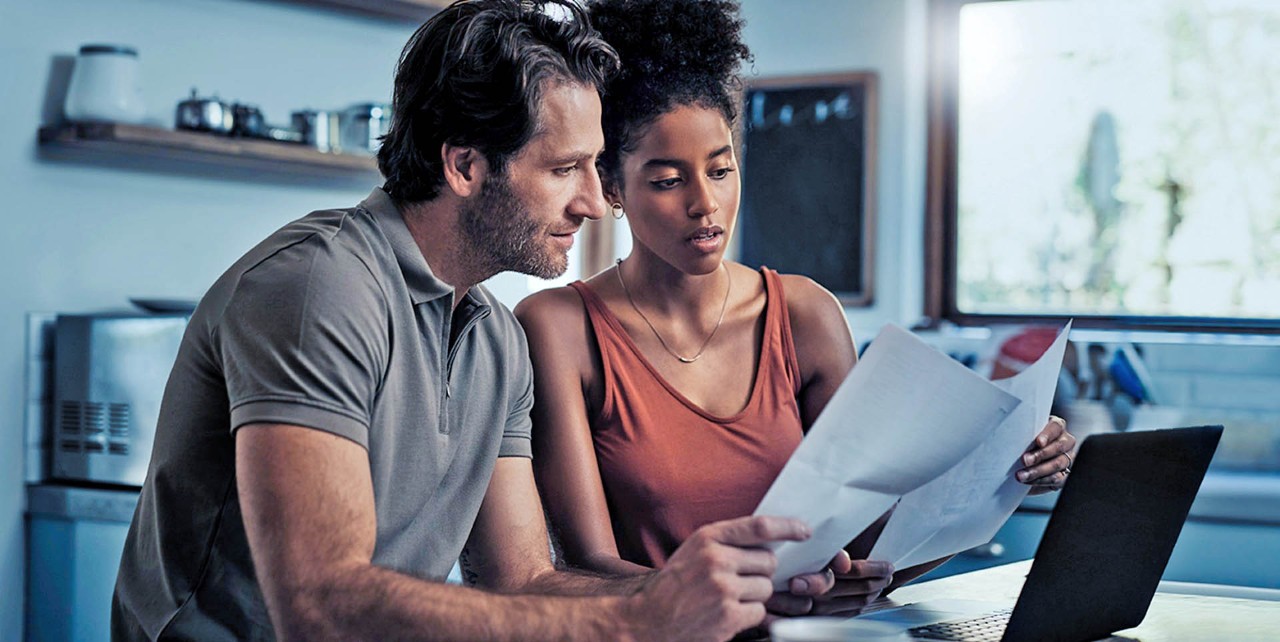 Man en vrouw kijken naar papieren achter laptop.jpg
