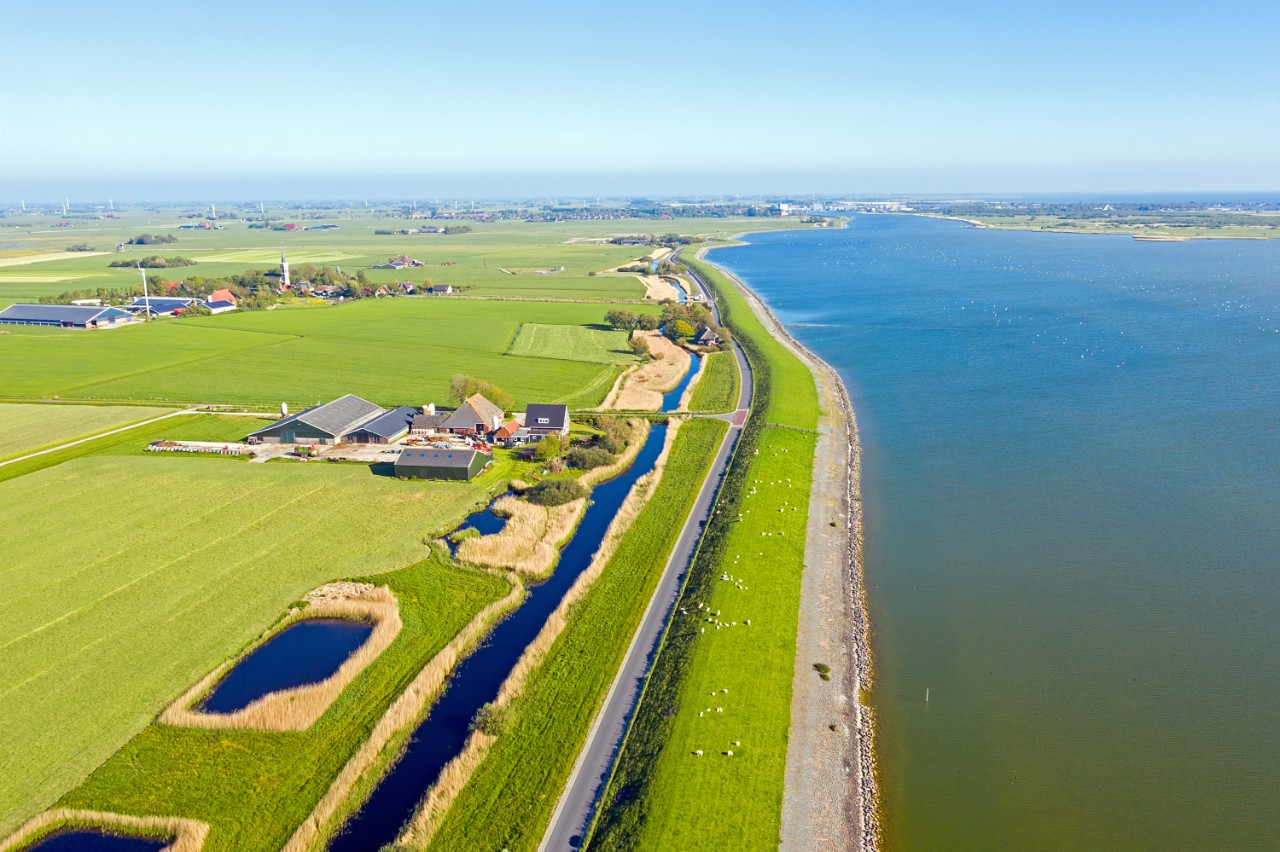 Landschap met dijk en water van boven gezien
