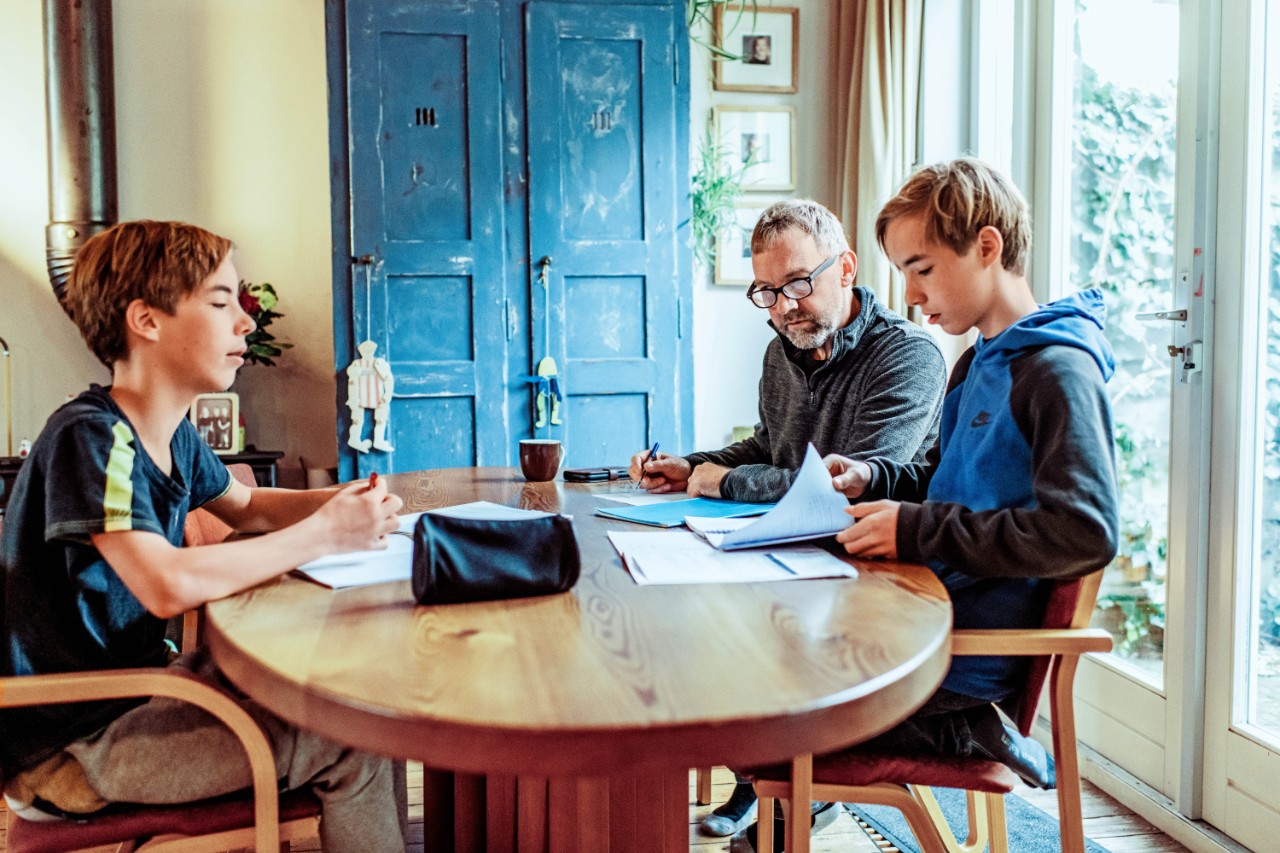 vader met twee zoons aan tafel huiswerk