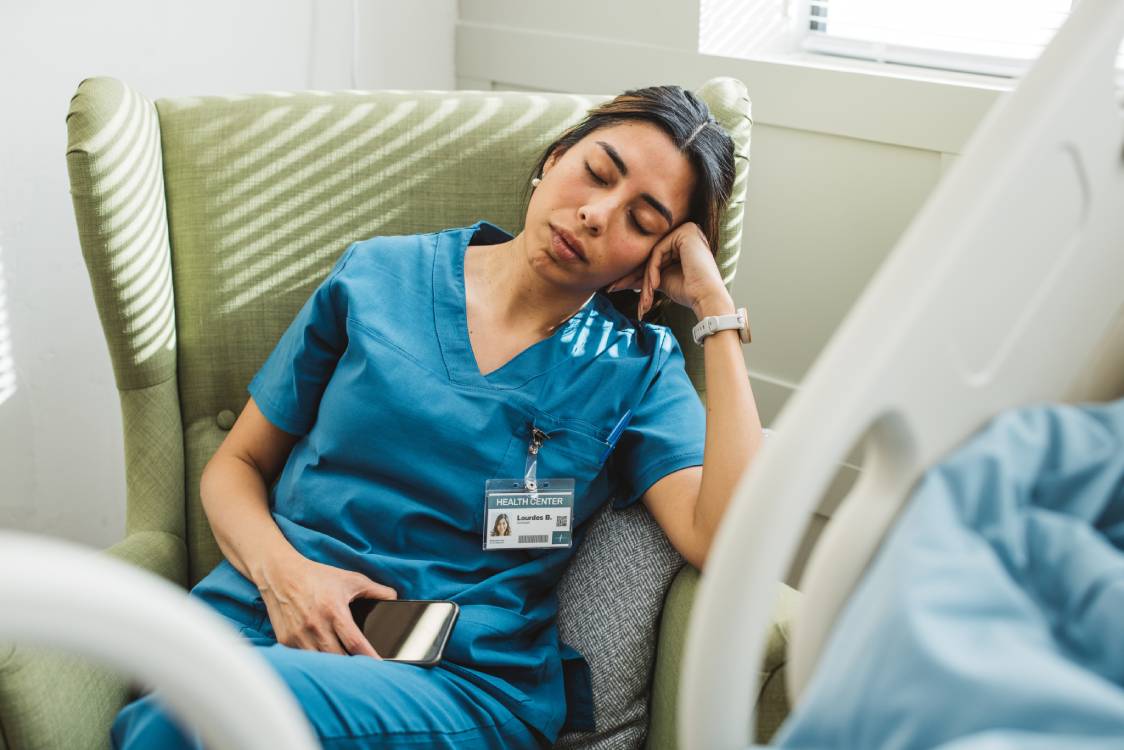 Verpleegkundige maakt notities aan bed van patient