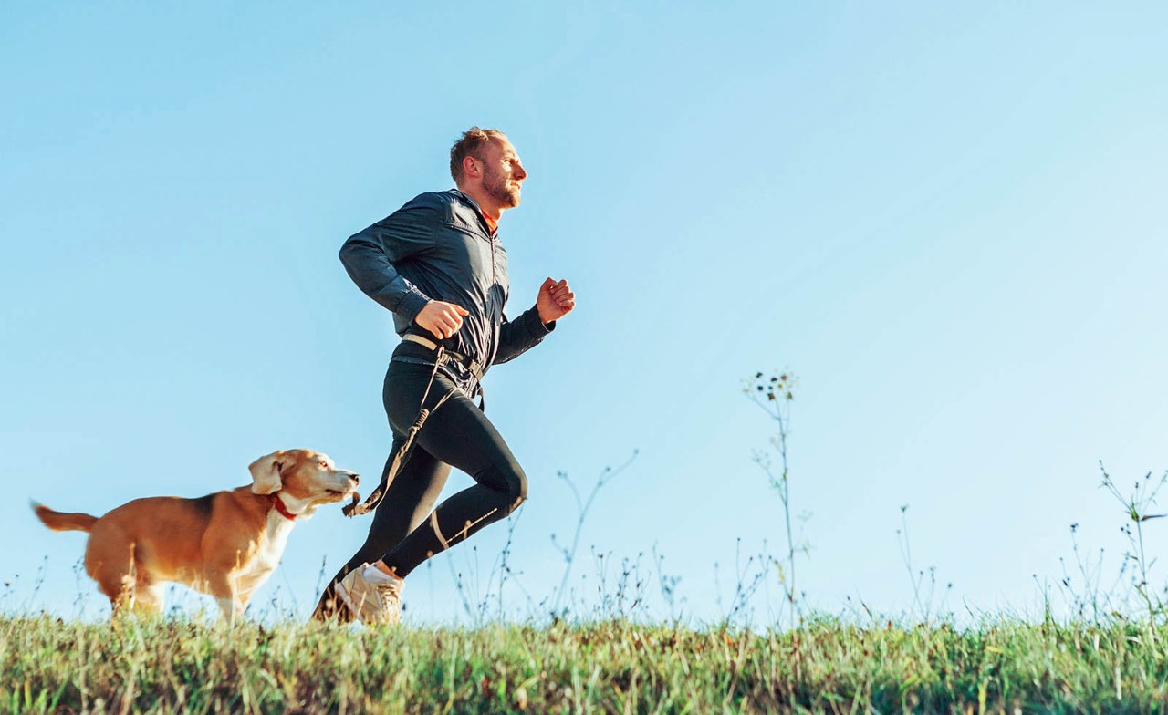 Man loopt hard met hond