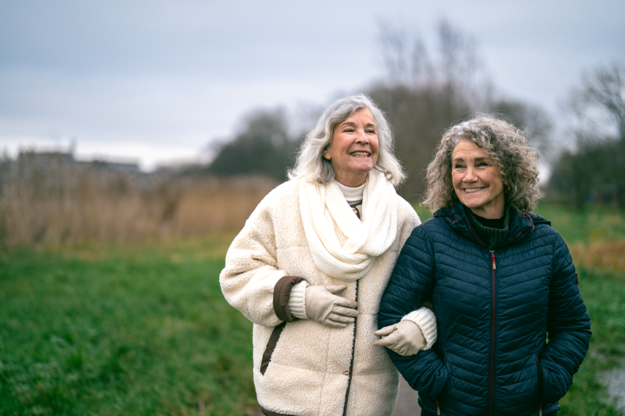 Twee vrouwen wandelen arm in arm buiten