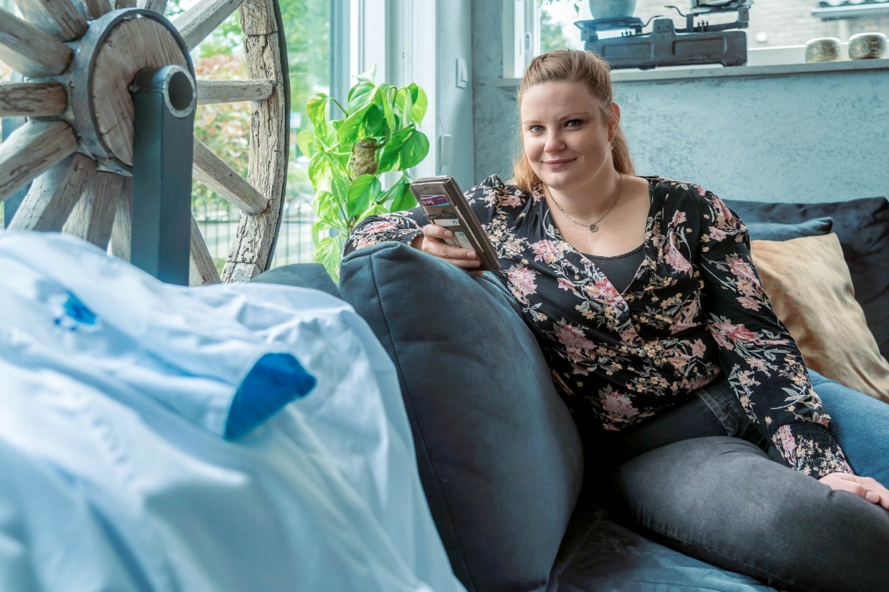 Annemarie met baby op de bank en werkjas op voorgrond