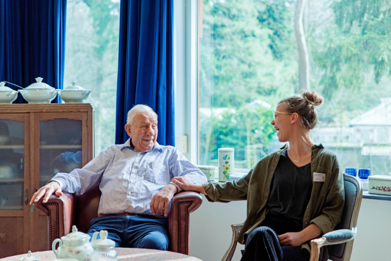 begeleider met bejaarde man kletsen