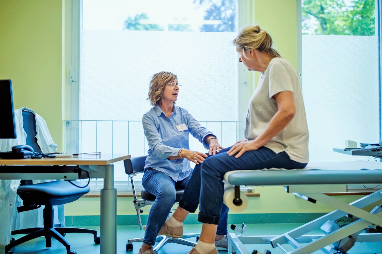 Dokter zit aan telefoon achter computerscherm