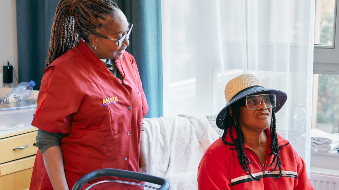 Verzorgster Henna met client met hoed