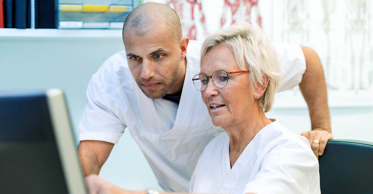 Verzorger loopt arm in arm met client
