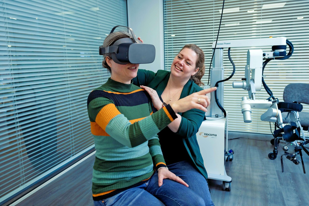 Kyra zet VR-bril op bij patiënt