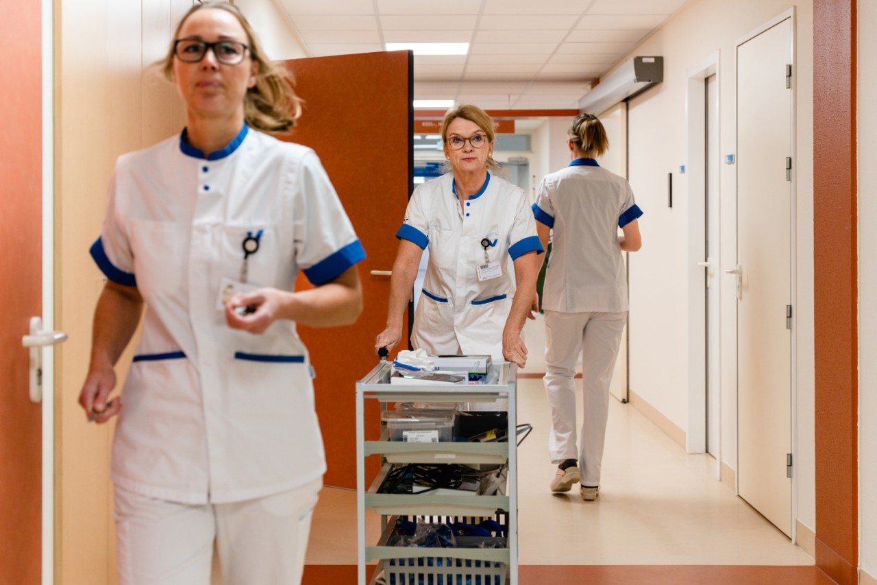 Drie verpleegsters lopen door de gangen van het ziekenhuis