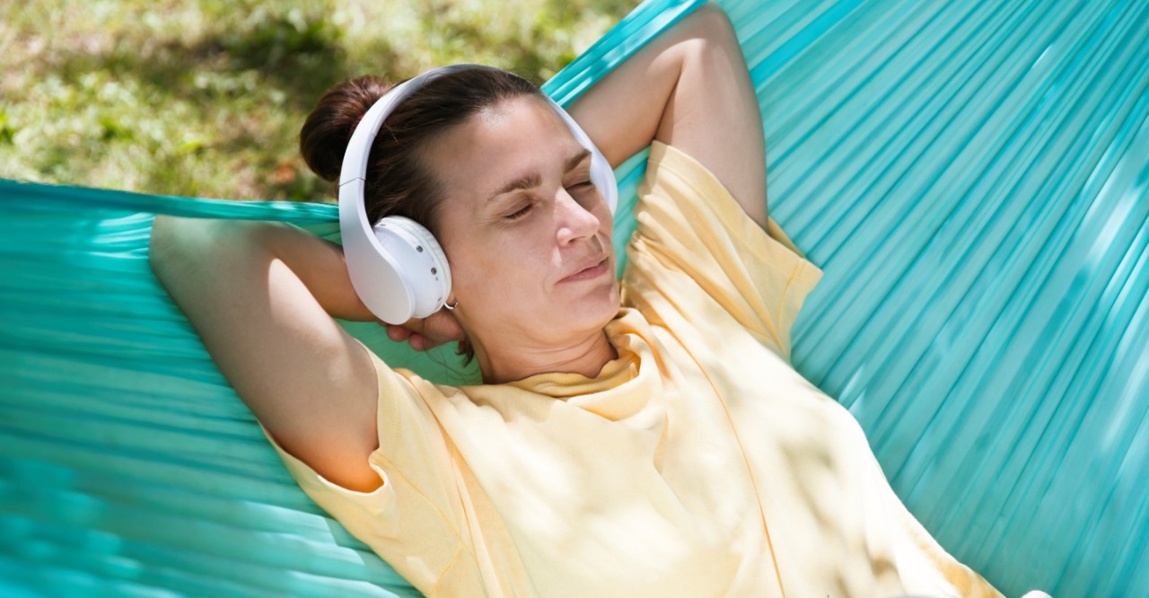 Vrouw in hangmat met koptelefoon