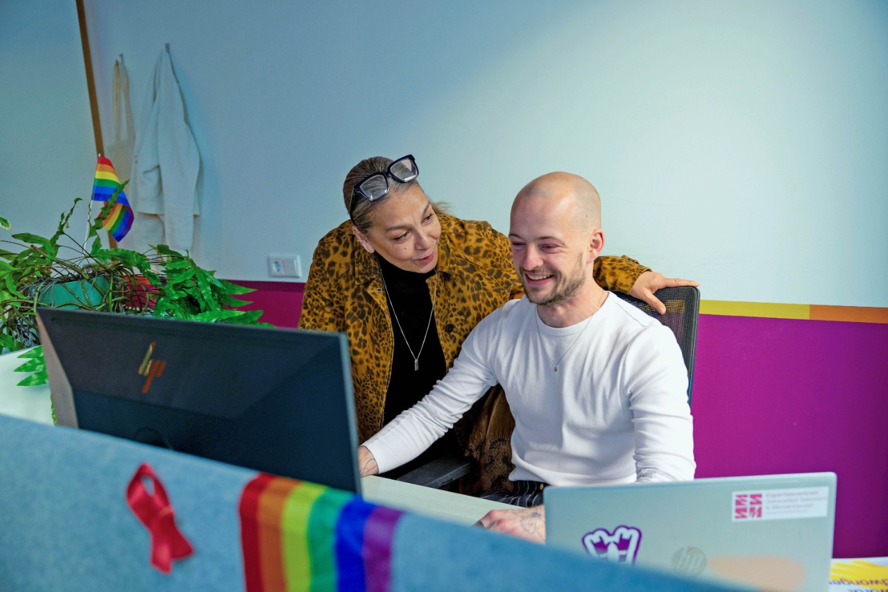 Mat met collega achter computer glimlachend
