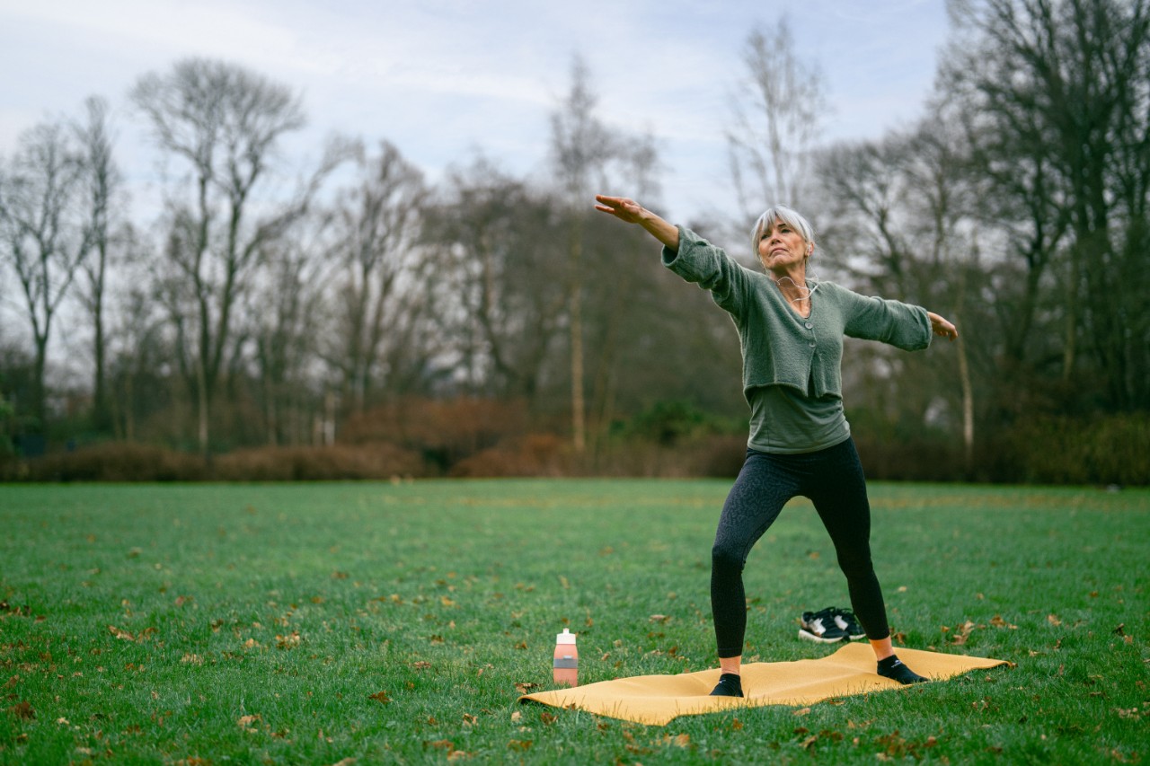 oudere dame yoga in park pensioen