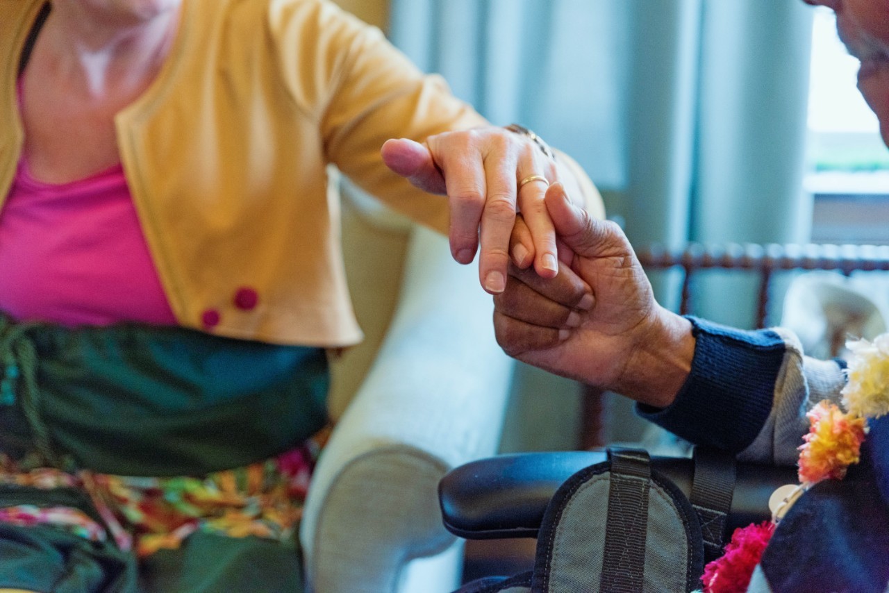 Twee oudere mensen pakken elkaars hand