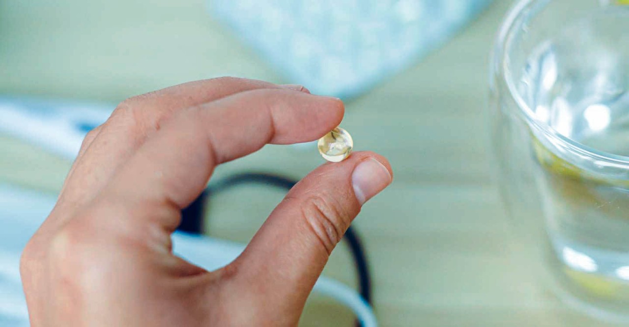 Hand met pil vitamine D