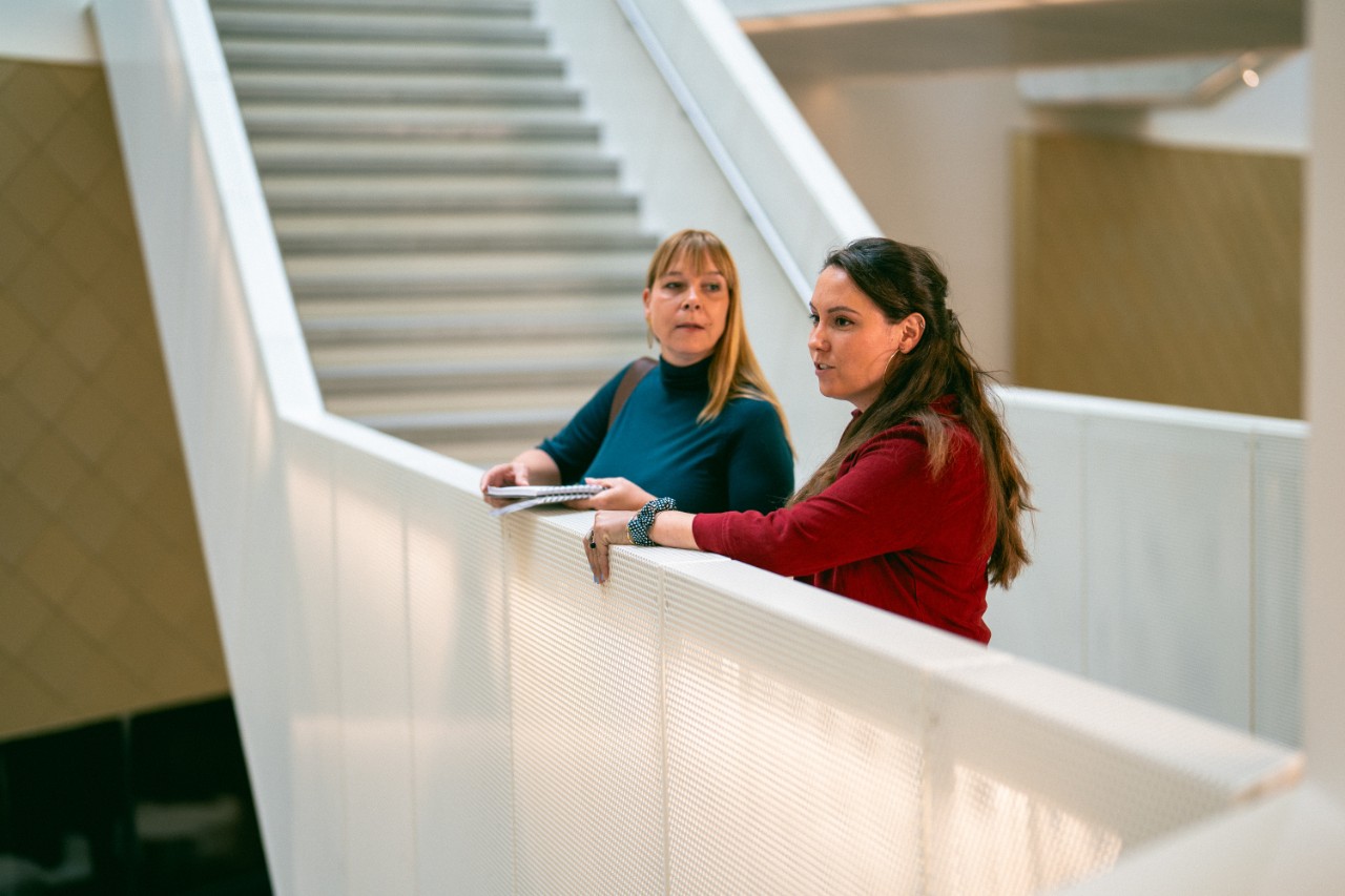 twee docenten in school overleg overloop
