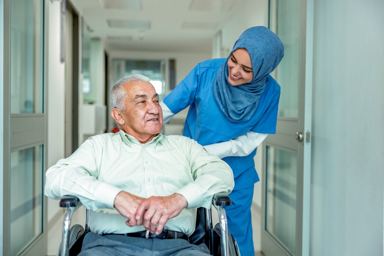 oudere man in rolstoel met verpleegkundige_vrouw_diversiteit