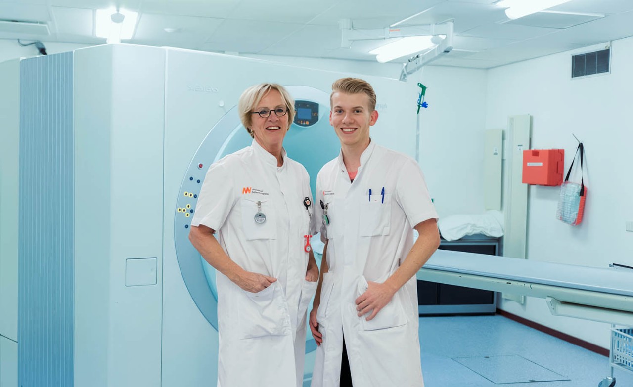 Verpleegkundige kijkt naar patiënt en drukt op knop