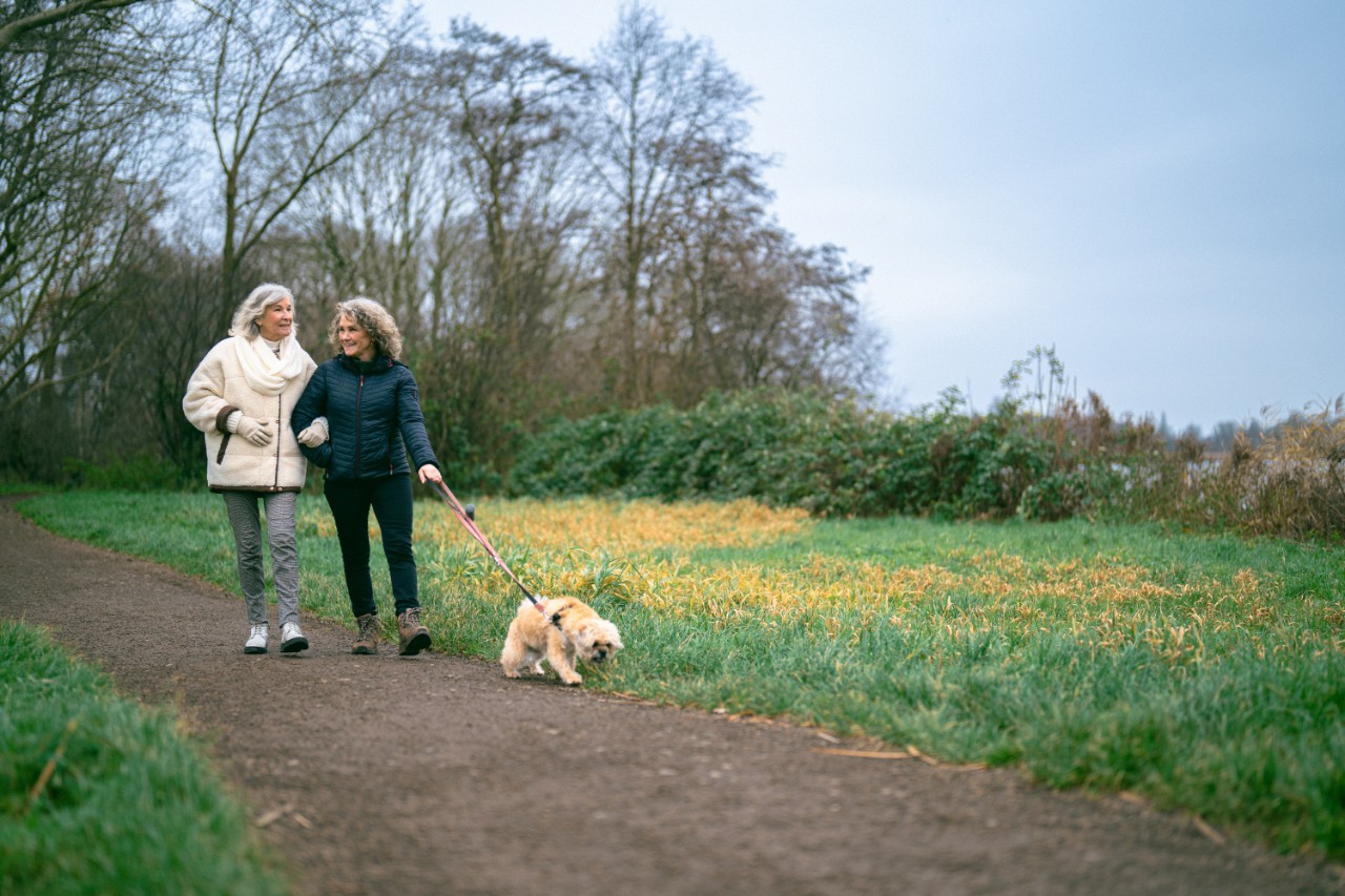 twee oudere dames wandelen met hond
