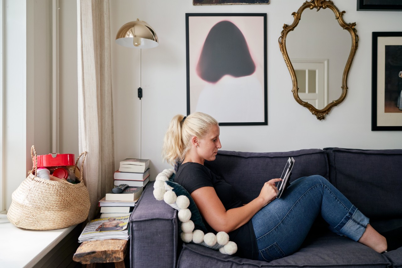 Vrouw met tablet op de bank