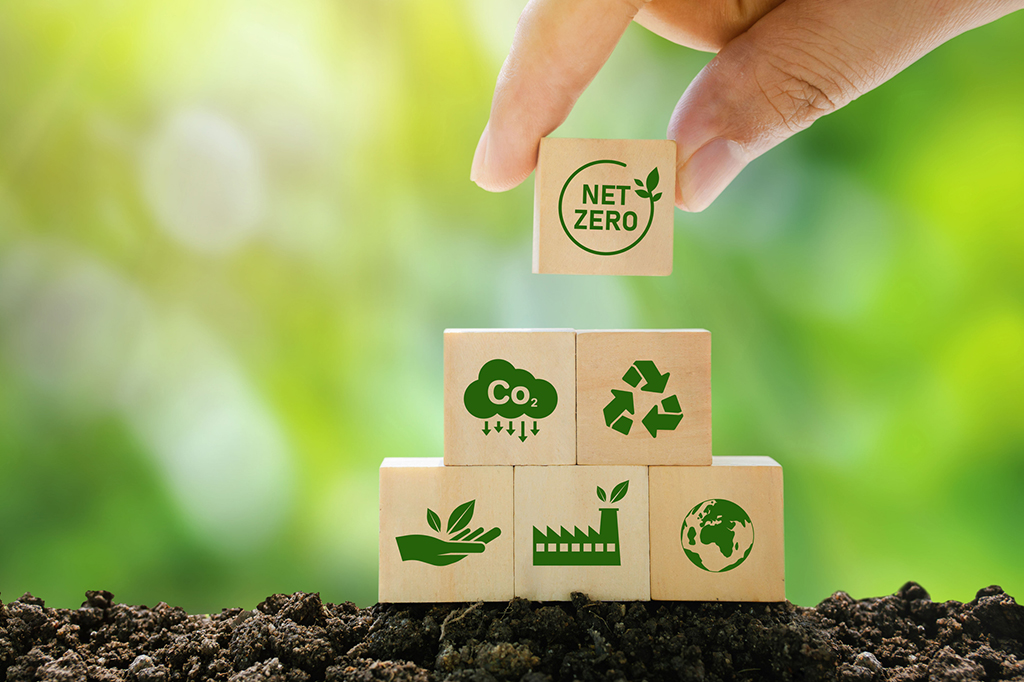 Net Zero and Carbon Neutral Concepts Net Zero Emissions Goals A climate-neutral long-term strategy Ready to put wooden blocks by hand with green net center icon and green icon on gray background.
