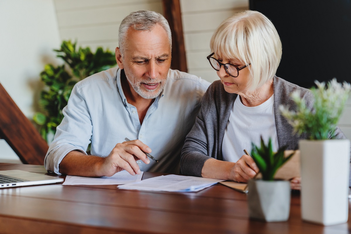 Mature couple with financial documents in home interior