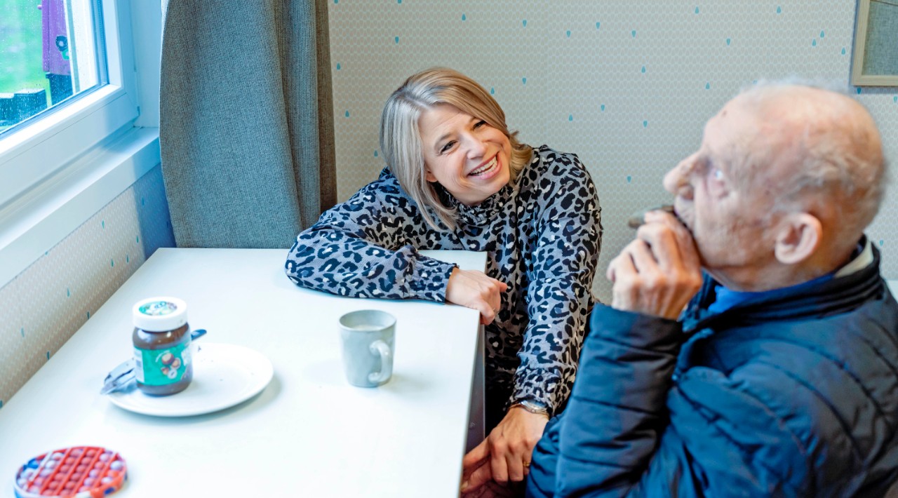 begeleider met bejaarde koffie met koek