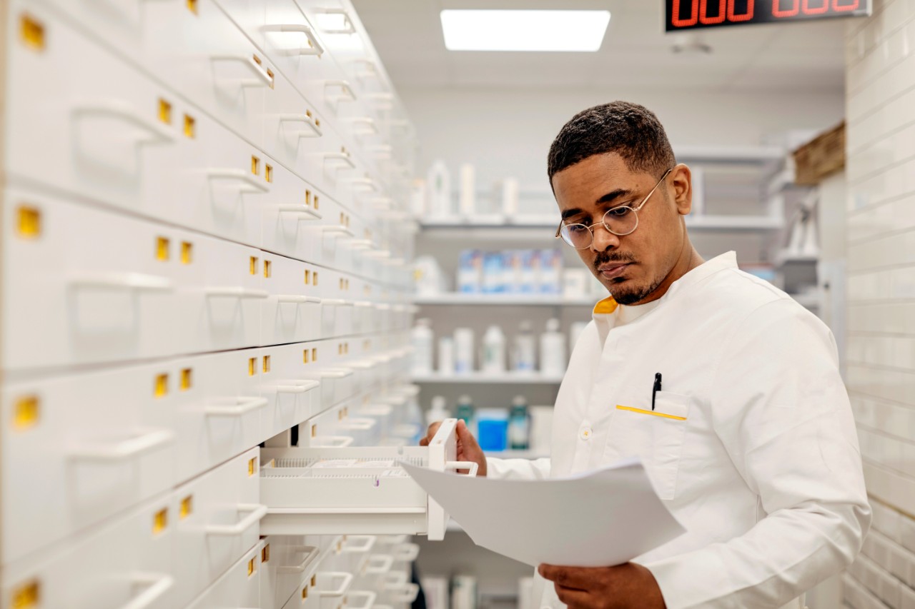 Apotheker bekijkt een recept bij een ladenkast