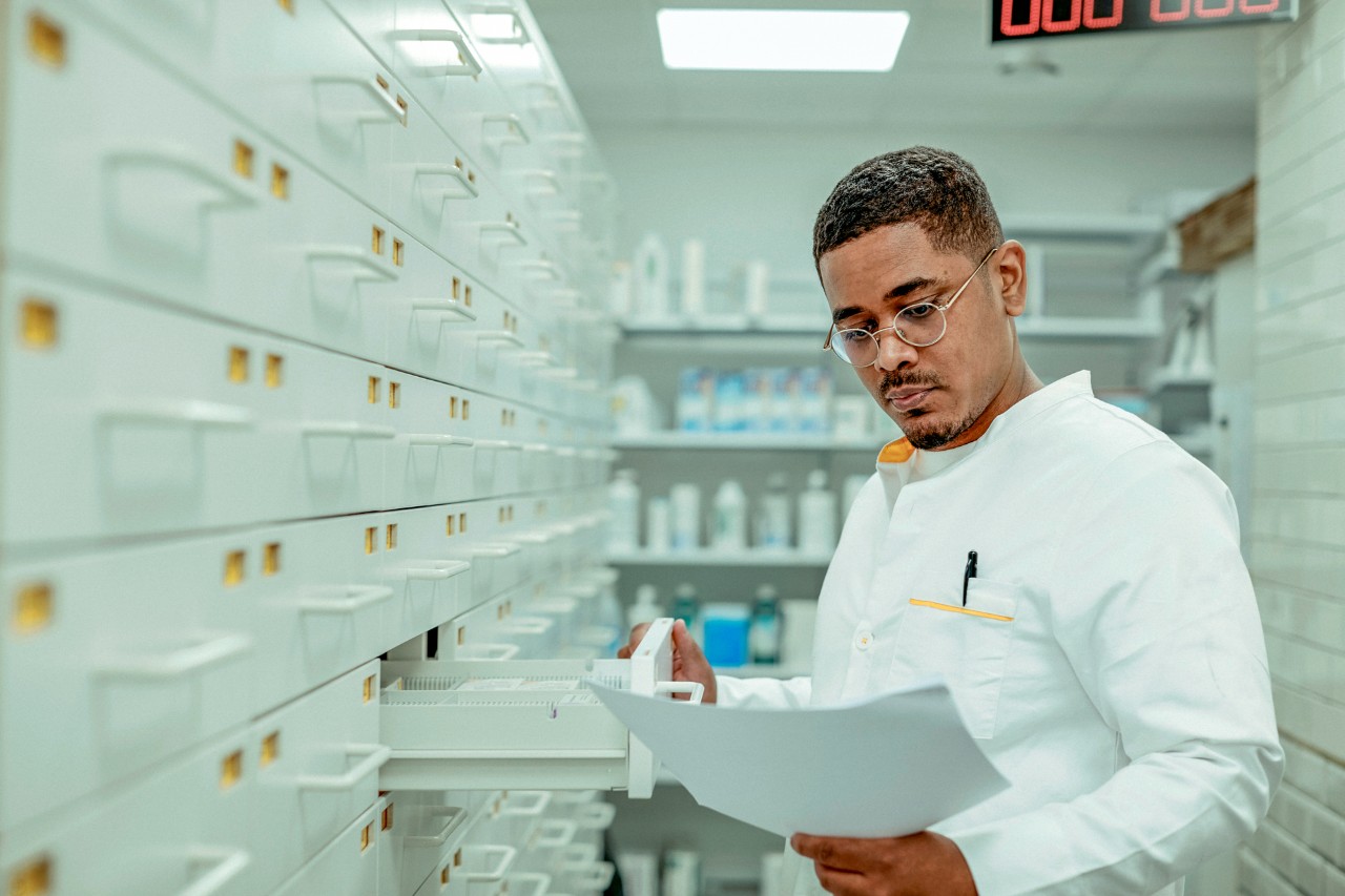 Apotheker bekijkt een recept bij een ladenkast