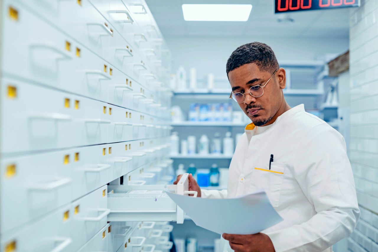 Apotheker bekijkt een recept bij een ladenkast